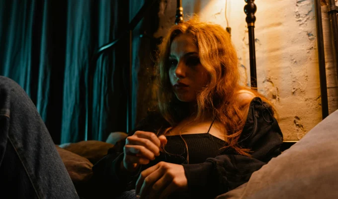 Young woman sitting in bed at night looking worried, torn between intuition and anxiety