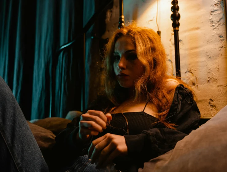 Young woman sitting in bed at night looking worried, torn between intuition and anxiety